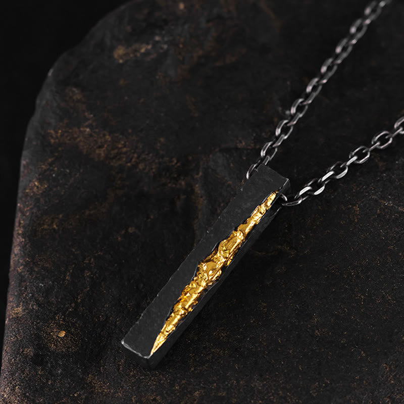 Om Mani Padme Hum Necklace – dark silver pendant with textured gold inlay, side-angle on stone, men's artisan jewelry