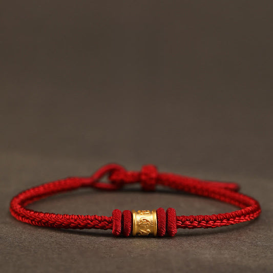 999 Gold Om Mani Padme Hum Red String Bracelet – braided red cord with gold mantra bead on neutral textured surface, red string bracelet