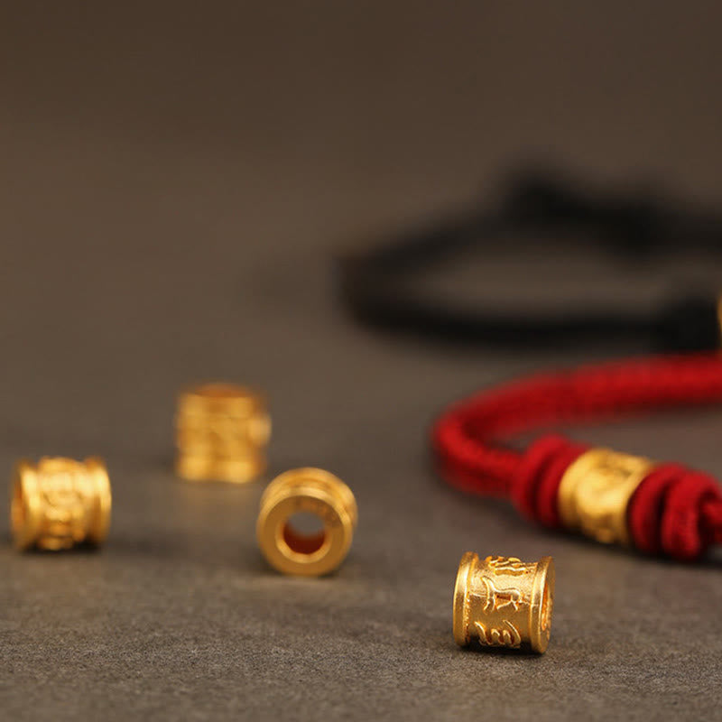 999 Gold Om Mani Padme Hum Red String Bracelet – scattered 999 gold charm beads with red bracelet in background, gold bead detail