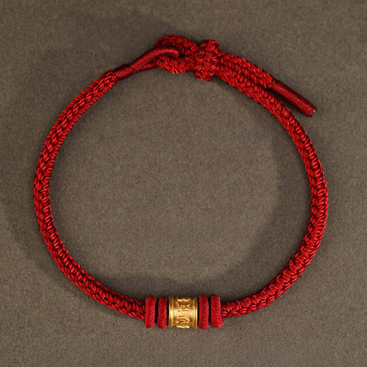 999 Gold Om Mani Padme Hum Red String Bracelet – overhead flat lay showing adjustable knot and gold cylinder bead, lucky bracelet