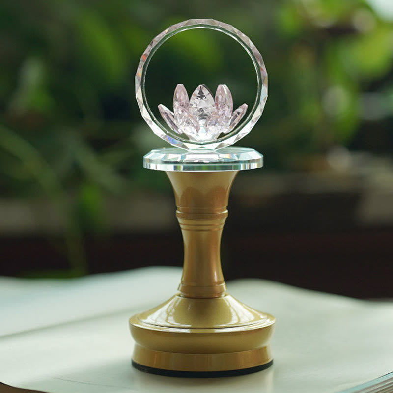 Gold pedestal crystal lotus ring on light surface with greenery, lotus ornament