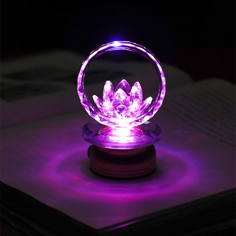 Purple LED crystal lotus ring lamp on book pages, color-changing lotus light