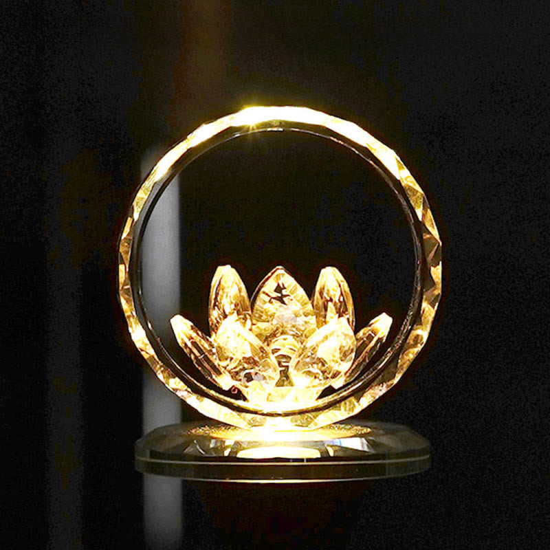 Crystal lotus in faceted ring on lit base against black, golden glow lotus lamp