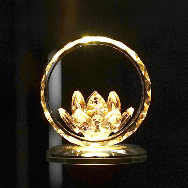 Crystal lotus in faceted ring on lit base against black, golden glow lotus lamp
