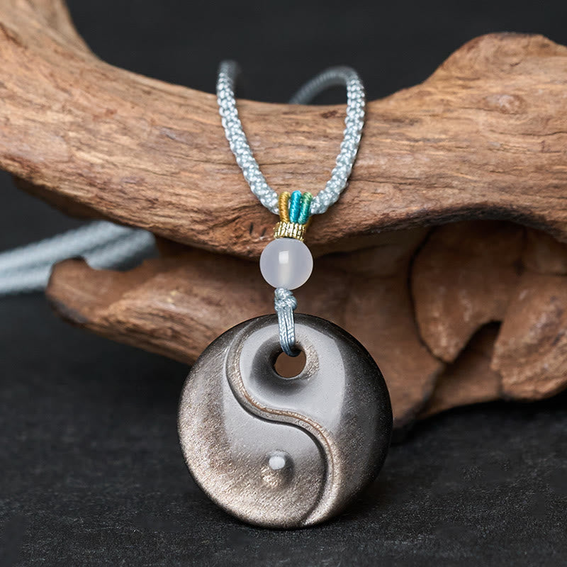 Silver Sheen Obsidian Yin Yang Pendant – front view on driftwood, yin yang necklace