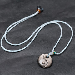 Silver Sheen Obsidian Yin Yang Pendant – flat lay with braided cord, men's necklace