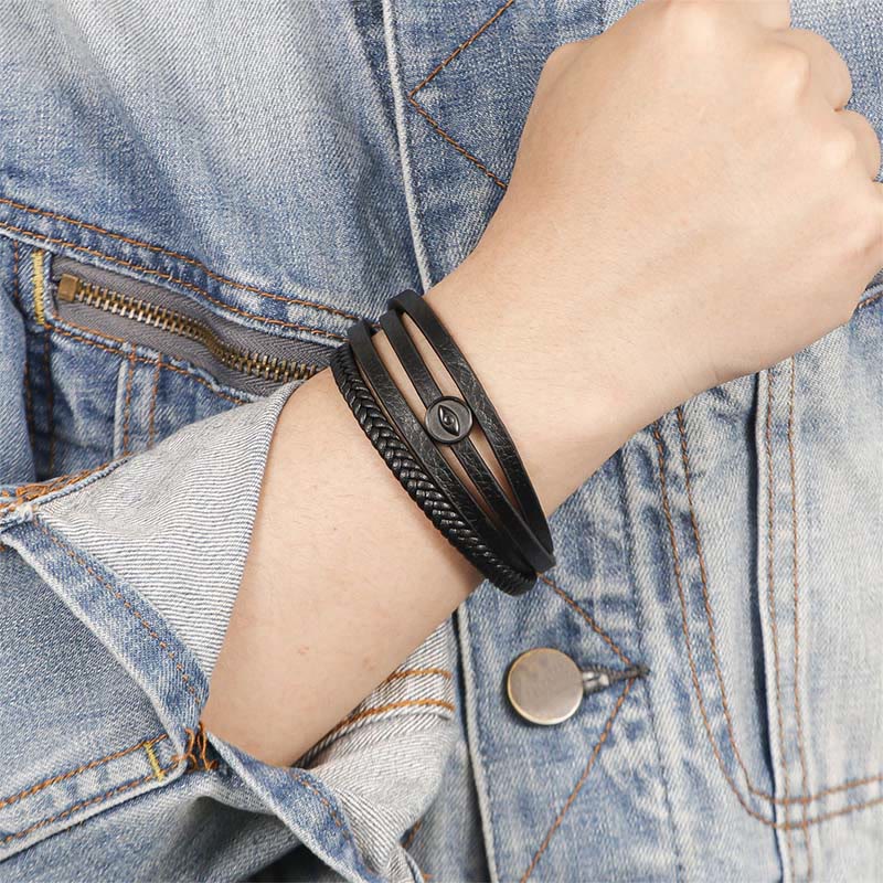 Leather Balance Bracelet – Black leather bracelet worn on wrist over blue denim, evil eye detail
