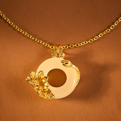 Gold lotus flower jade bi disc pendant necklace on amber background, traditional jade necklace