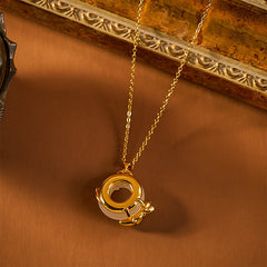 Gold circular ring pendant necklace with cream jade center on brown background, vintage gold necklace
