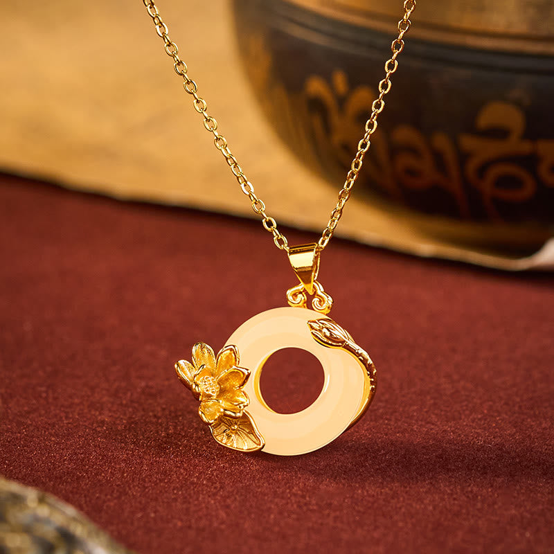 Gold lotus jade bi disc pendant necklace with 3D carved floral details on burgundy velvet, lotus jewelry