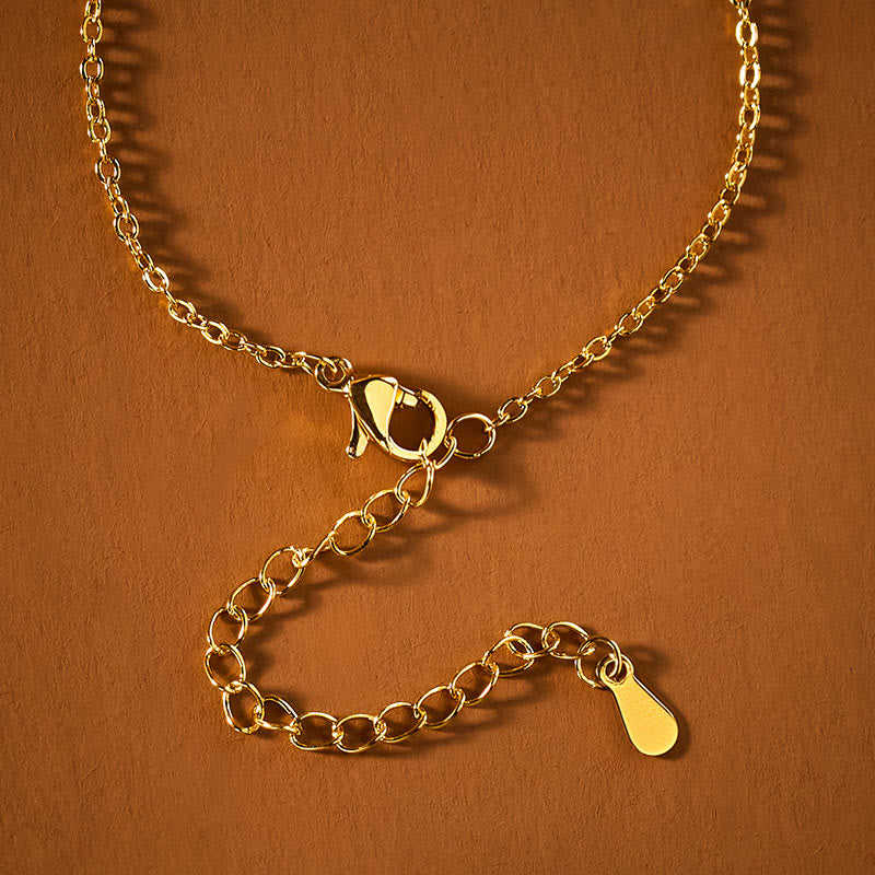 Gold cable chain necklace with lobster clasp and adjustable extender, close-up jewelry hardware