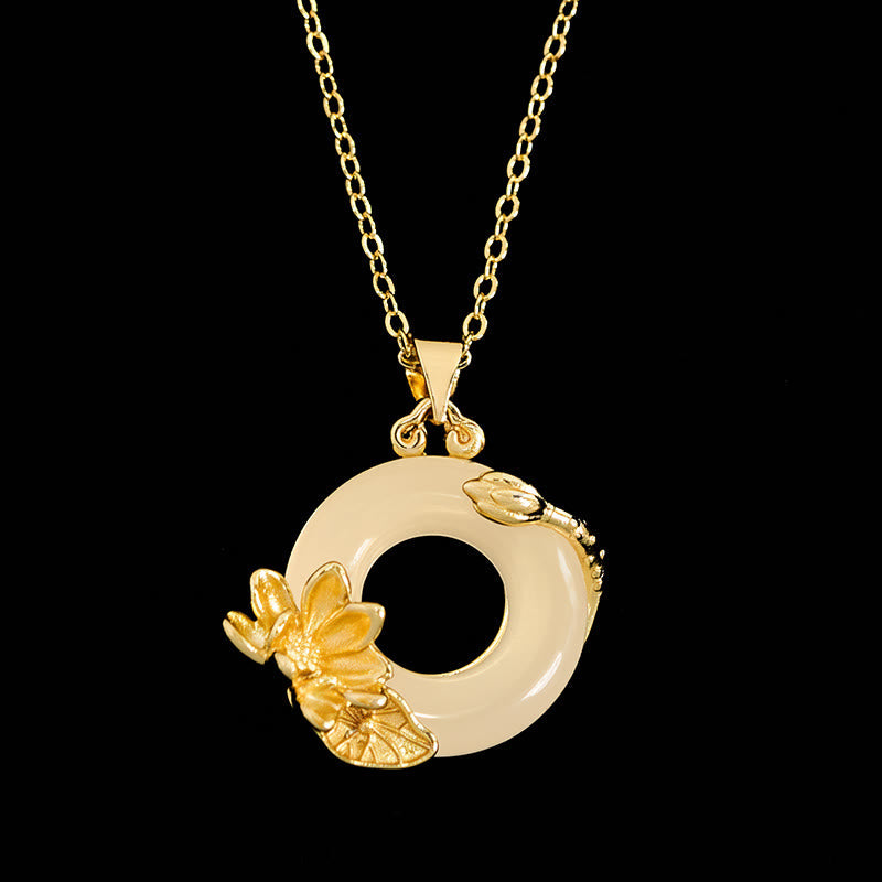Gold lotus flower and jade ring pendant necklace on black background, minimalist jade necklace