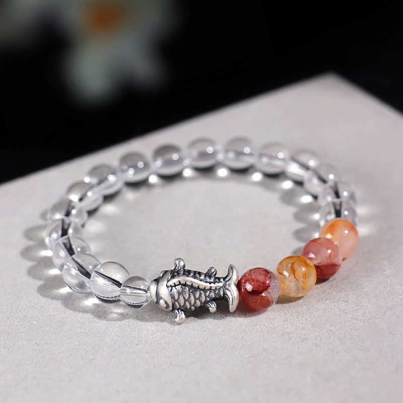 Clear Quartz Koi Fish Bracelet – near eye-level on light surface, crystal beads with warm gradient, silver koi detail