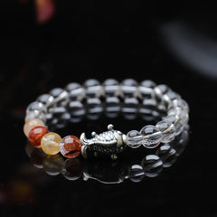 Clear Quartz Koi Fish Bracelet – three-quarter on reflective black, clear beads with red-gold accents, koi charm