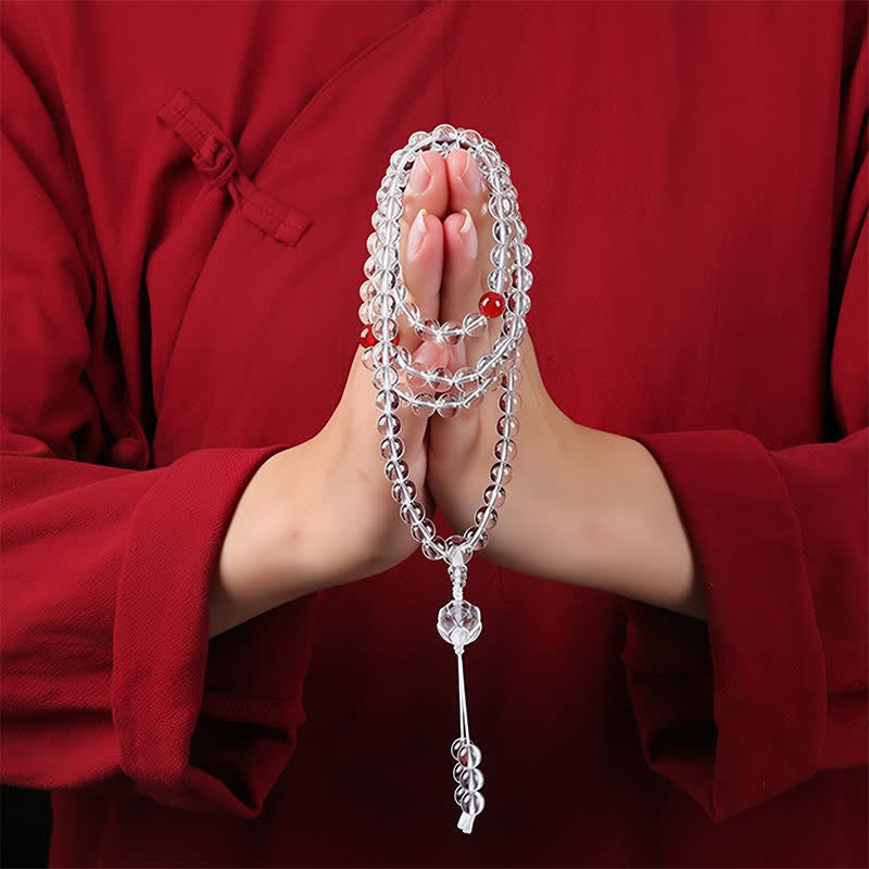 Liuli Lotus 108 Bead Mala - held in prayer hands on red garment, crystal meditation beads lifestyle