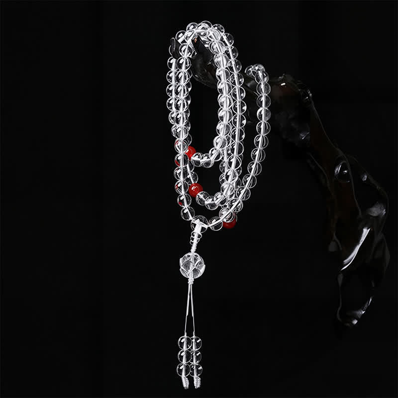 Liuli Lotus 108 Bead Mala - draped over dark sculptural prop, clear crystal mala with guru bead tassel