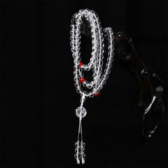 Liuli Lotus 108 Bead Mala - draped over dark sculptural prop, clear crystal mala with guru bead tassel