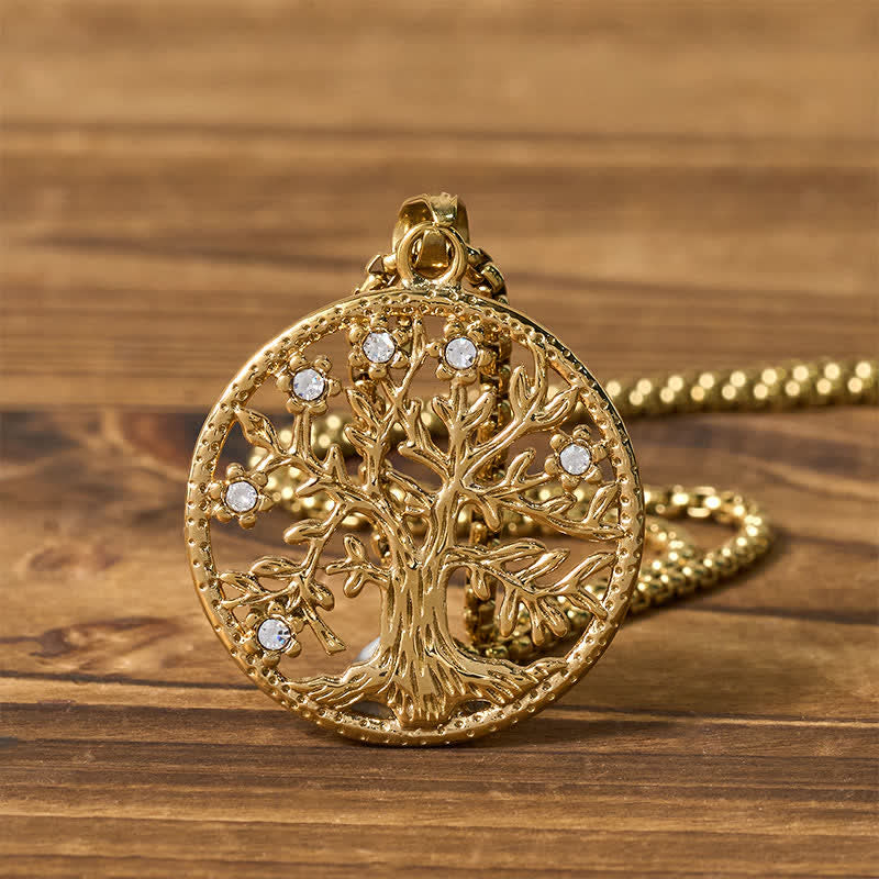 Tree of Life Titanium Steel Necklace – Gold pendant flat lay on wood with chain coiled behind, shiny