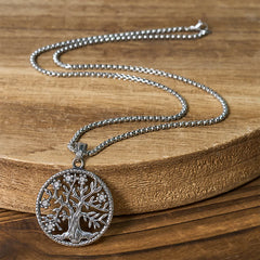 Tree of Life Titanium Steel Necklace – Full silver necklace on natural wood slab showing chain length