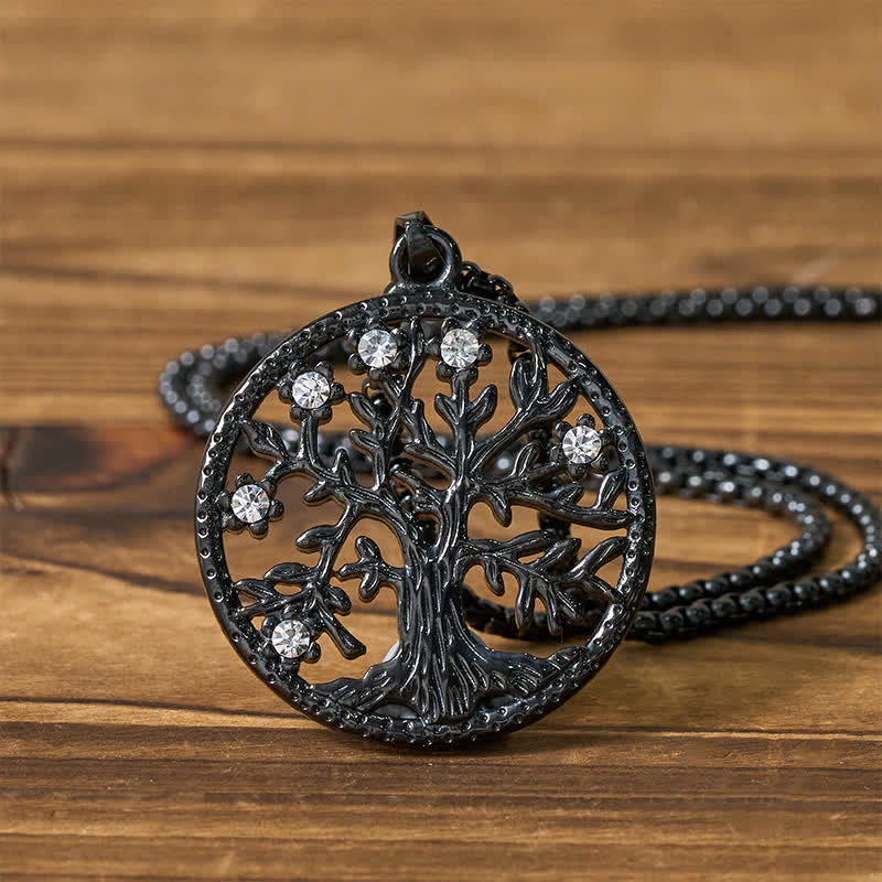 Tree of Life Titanium Steel Necklace – Black pendant flat lay on wood with chain behind, detailed shot
