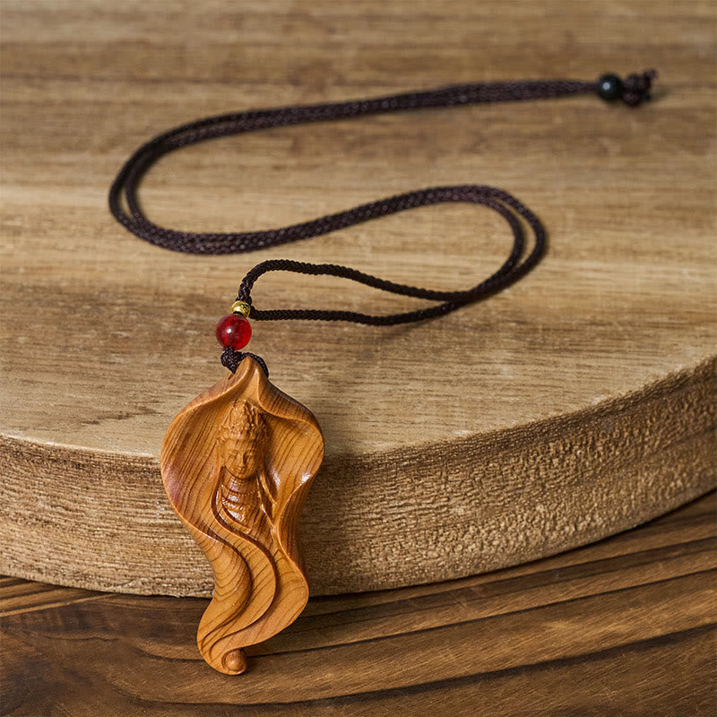 Guanyin Avalokitesvara Platycladus Wood Wealth Necklace Pendant – wood pendant on stone surface, earthy spiritual jewelry