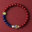 Cinnabar Lapis Lazuli Koi Fish Bracelet – red and blue bead bracelet with koi charm on burgundy fabric