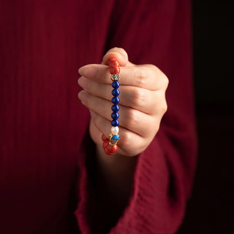 Cinnabar Lapis Lazuli Koi Fish Bracelet – hand-held display showing full bracelet, vertical presentation