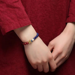 Cinnabar Lapis Lazuli Koi Fish Bracelet – worn on wrist with clasped hands, lifestyle red garment styling