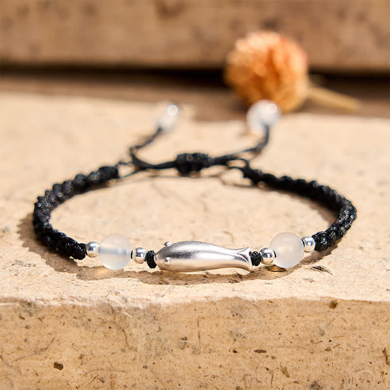 999 Sterling Silver Koi Fish Bracelet – silver koi charm with white agate on black braided rope, stone surface