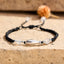 999 Sterling Silver Koi Fish Bracelet – silver koi charm with white agate on black braided rope, stone surface