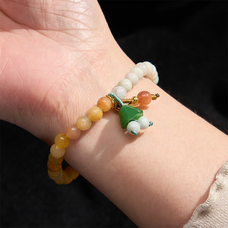 Carved green jade lotus pendant bracelet with carnelian and white beads, knotted cord detail
