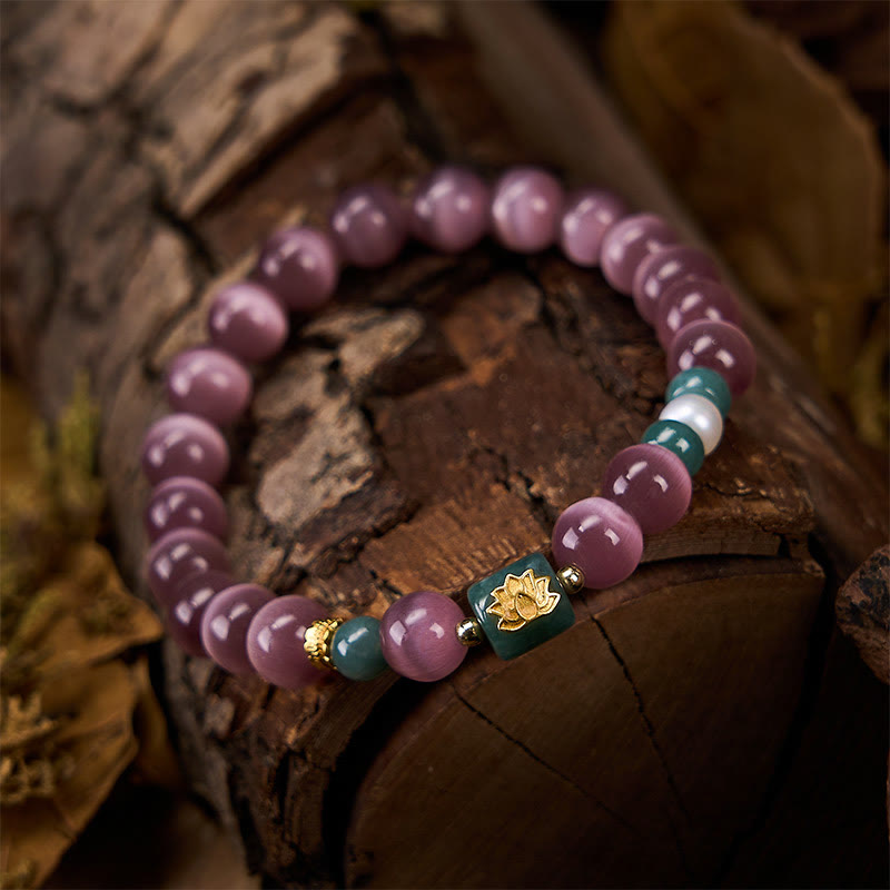 Purple Cat’s Eye Lotus Enlightenment Bracelet – Draped on earthy ceramic vase, pink cat’s eye beads with gold lotus inlay on teal stone
