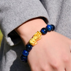 Natural Tiger Eye Pixiu Fu Om Mani Padme Hum Bracelet – close-up blue tiger eye bracelet on wrist with grey fabric