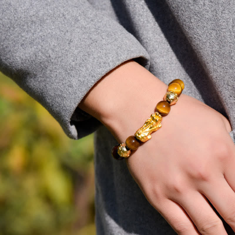 Natural Tiger Eye Pixiu Fu Om Mani Padme Hum Bracelet – outdoor wrist shot grey coat and golden Pixiu tiger eye bracelet