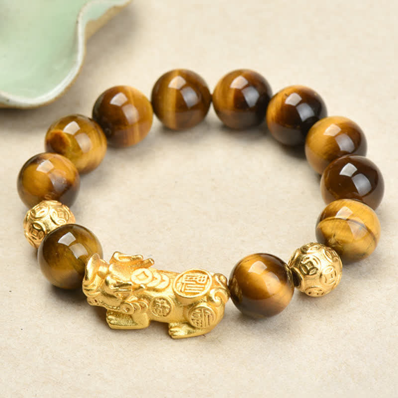 Natural Tiger Eye Pixiu Fu Om Mani Padme Hum Bracelet – golden Pixiu with brown tiger eye beads on cream surface, courage