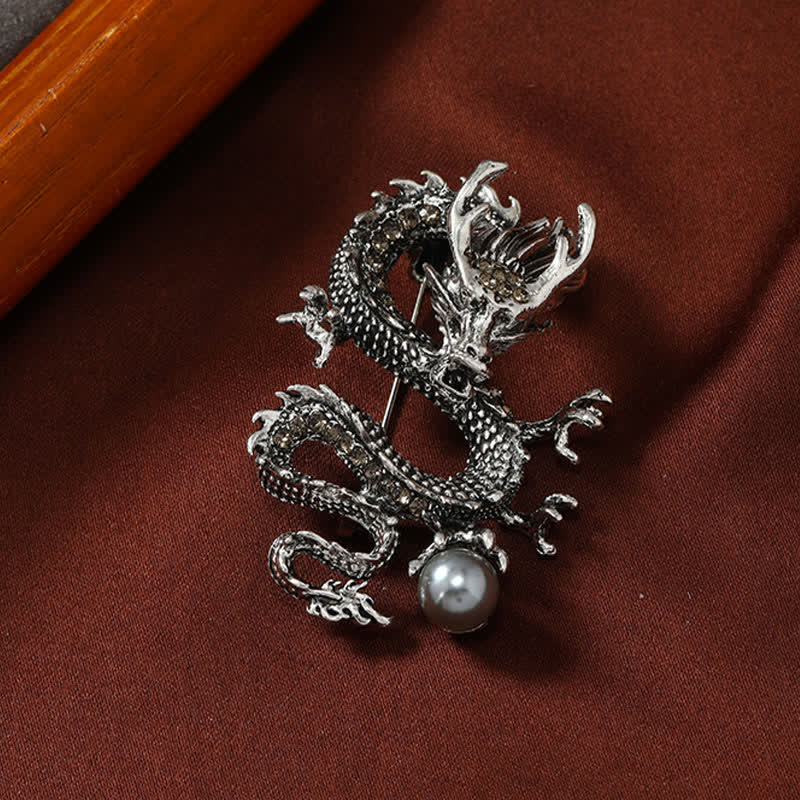 Domineering Dragon Pearl Strength Alloy Brooch – detailed silver dragon grasping pearl on rich maroon fabric, luck