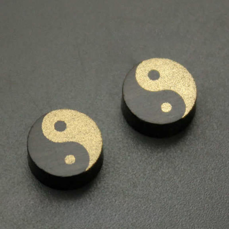 Ebony Wood Yin Yang Stud Earrings - Two gold and black yin yang circular studs on neutral surface, harmony earrings