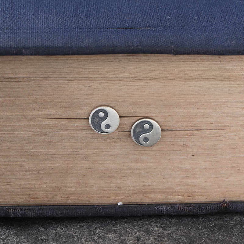 Yin Yang Stud Earrings - Flat lay pair on wood and fabric, antique silver finish, zen jewelry