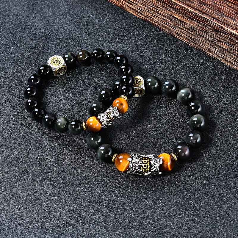 Natural Black Obsidian PiXiu Tiger's Eye Bracelet – two bracelets on dark surface with wood accent, feng shui wealth luck set