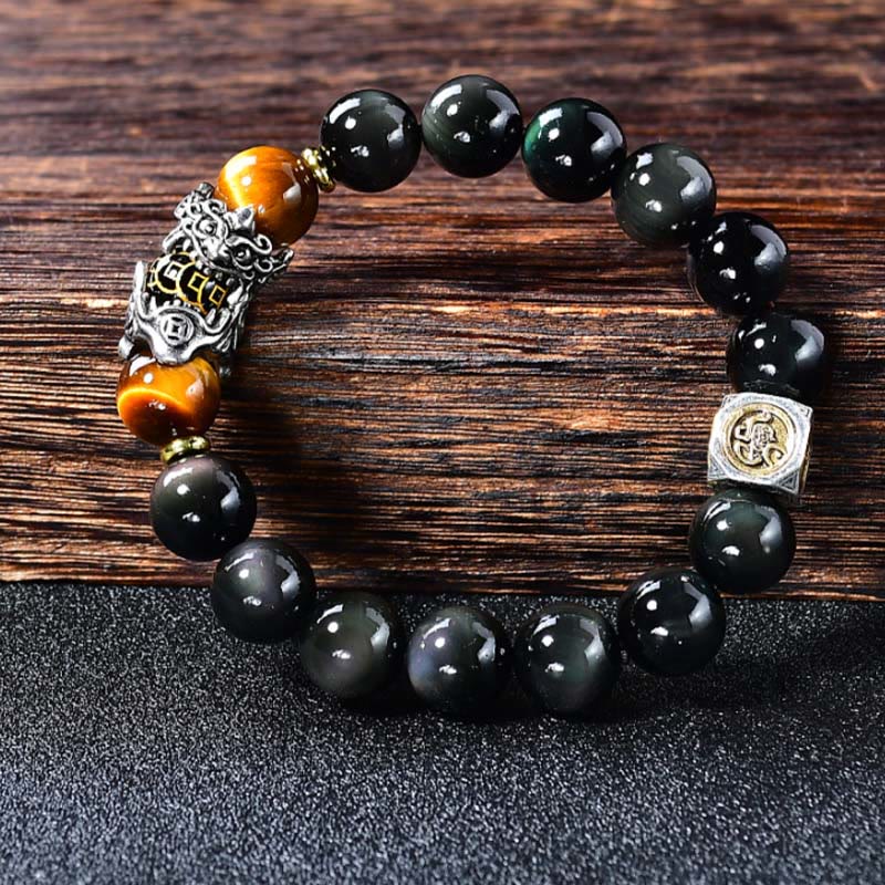 Natural Black Obsidian PiXiu Tiger's Eye Bracelet – bracelet on dark wood showing PiXiu detail, tiger eye and obsidian beads