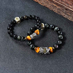 Natural Black Obsidian PiXiu Tiger's Eye Bracelet – two bracelets on dark surface with wood accent, feng shui wealth luck set
