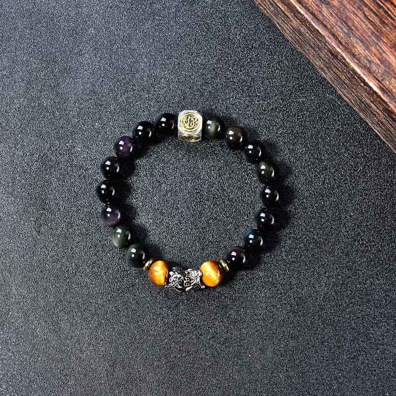 Natural Black Obsidian PiXiu Tiger's Eye Bracelet – top view circular on dark fabric showing obsidian and tiger eye beads