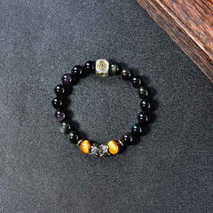 Natural Black Obsidian PiXiu Tiger's Eye Bracelet – top view circular on dark fabric showing obsidian and tiger eye beads
