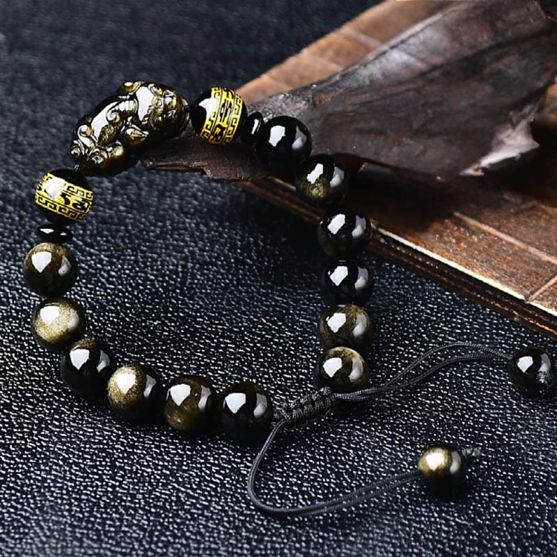 Gold Sheen Obsidian PiXiu Bracelet – Draped over dry leaf, gold Pi Xiu bead, black gold obsidian, natural wealth jewelry