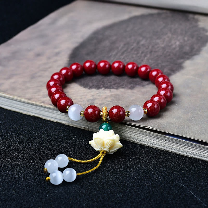 Cinnabar Cat's Eye Lotus Blessing Bracelet - red beads with carved lotus charm on ink-wash book, spiritual jewelry