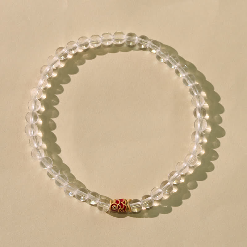 Clear Quartz Koi Fish Bracelet - clear crystal bracelet on black reflective surface, koi accent