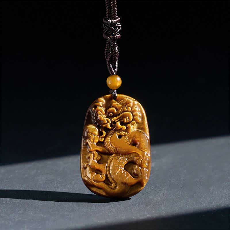 Tiger Eye Carved Dragon Rope Protection Necklace – relief-carved dragon with coin knot on dark slate, courage