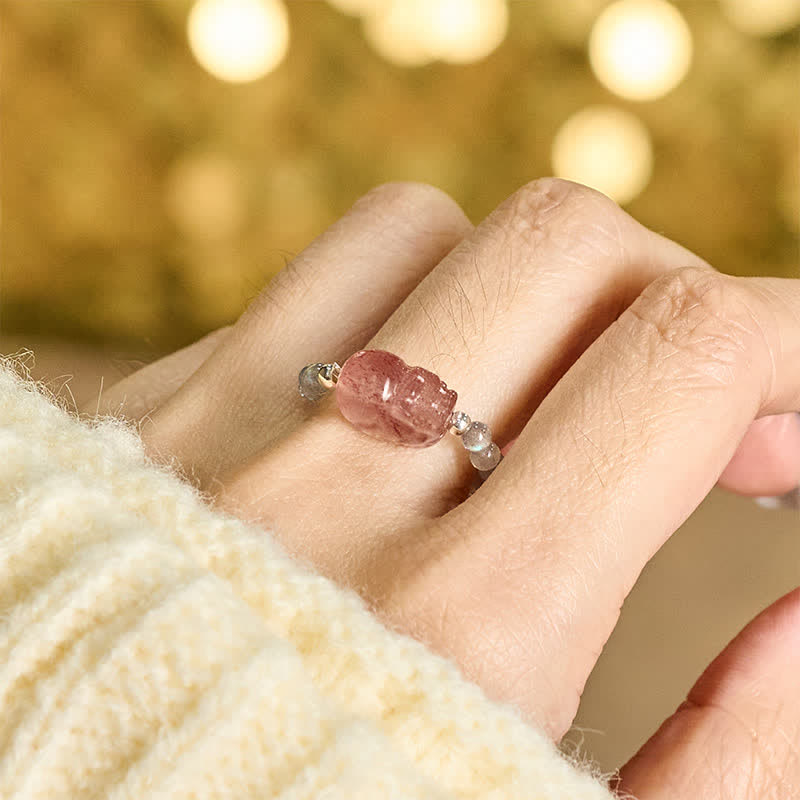 3mm PiXiu Gemstone Ring – Hand model wearing moonstone PiXiu ring, cream knit, golden bokeh light
