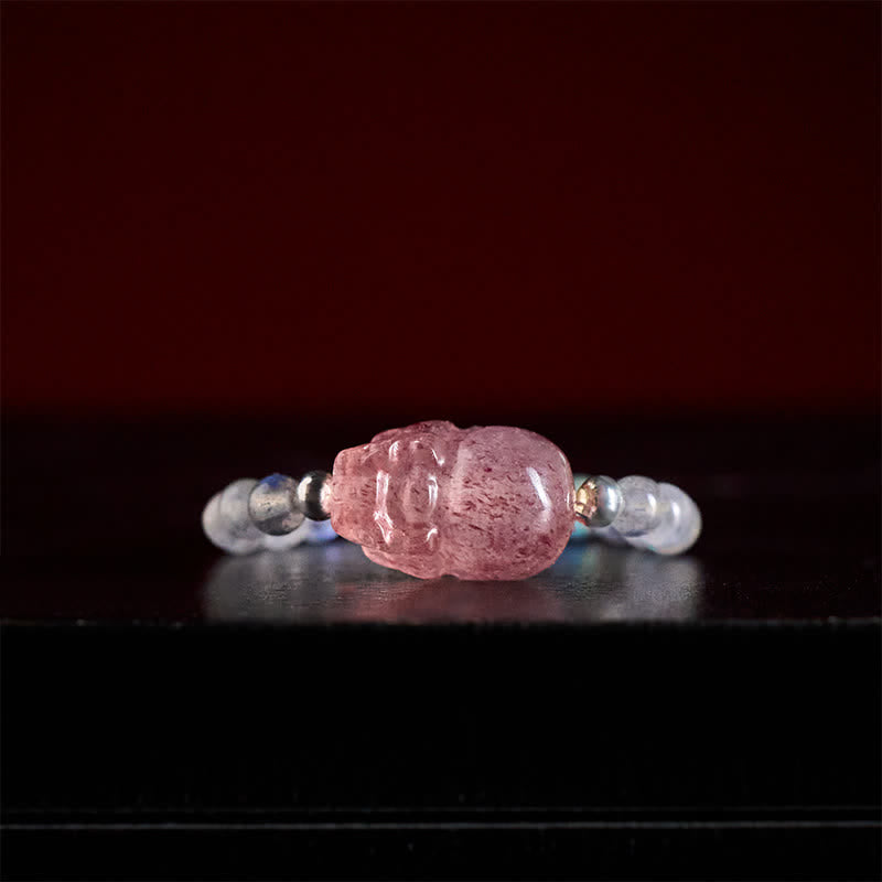 3mm PiXiu Gemstone Ring – Front view of PiXiu with moonstone beads on dark surface, mystical glow