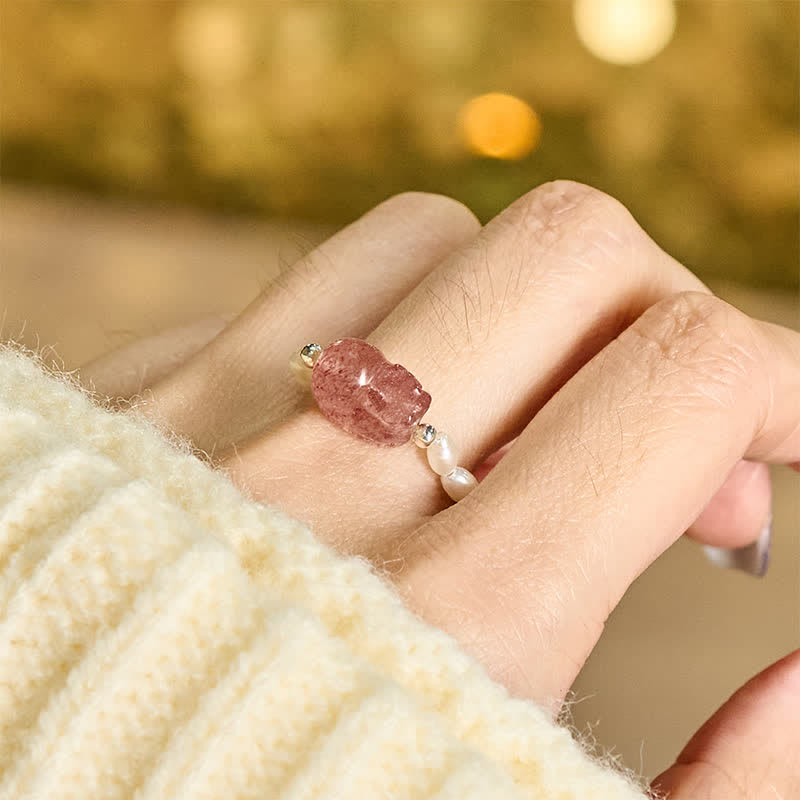 3mm PiXiu Gemstone Ring – Hand model wearing pearl PiXiu ring with cream knit, gold bokeh light